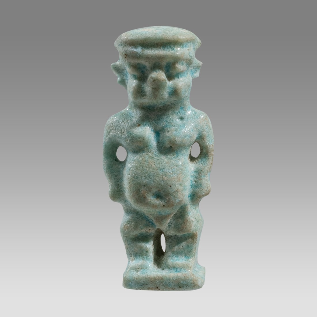 Ancient Egyptian Faience Amulet Of Dwarf Pataikos LATE PERIOD CIRCA 664-332 B.C.: Ancient Egyptian Faience Amulet Of Dwarf Pataikos LATE PERIOD CIRCA 664-332 B.C. Size 1 1/4 inch high. Light blue glazed faience Amulet of Dwarf Pataikos, Suspension hole at back. Provenance: Private