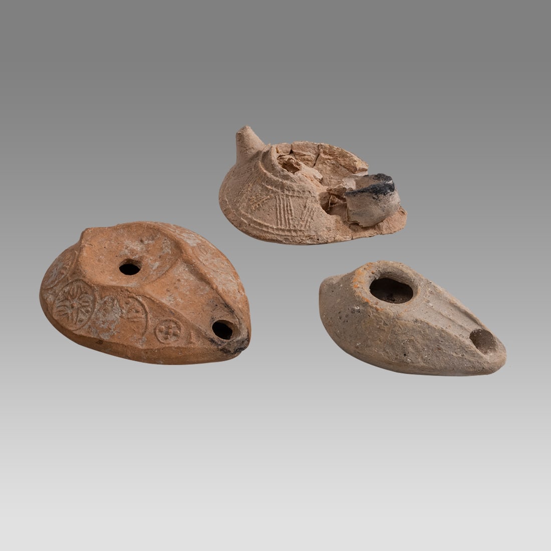 Lot of 3 Ancient Byzantine Terracotta Oil Lamps c.5th century AD.: Lot of 3 Ancient Byzantine Terracotta Oil Lamps c.5th century AD. Size 3 1/4 - 4 inches length. Lot of 3 terracotta oil lamps with design. One damaged as seen. Provenance: Private collection, bought v