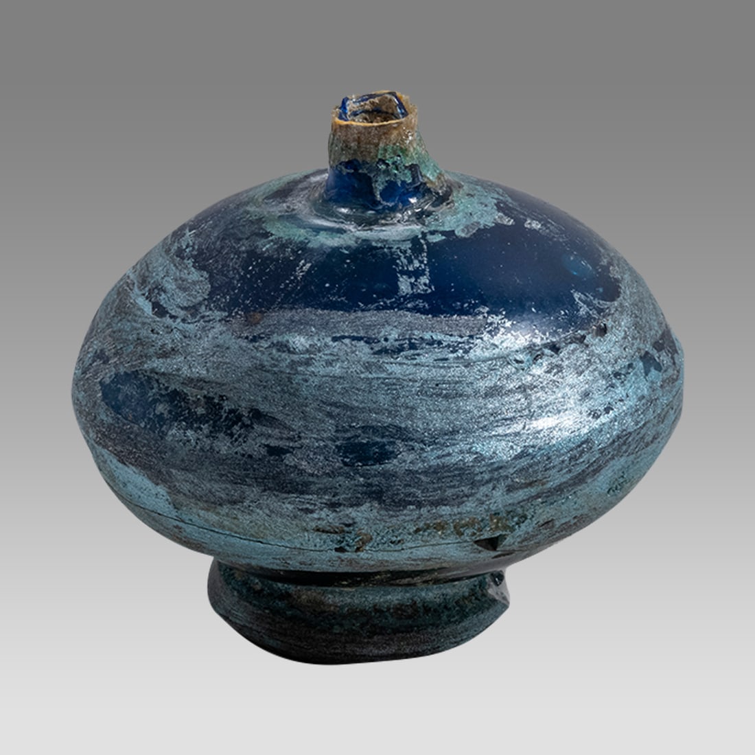 Islamic Blue Glass Footed Bottle.: Islamic Blue Glass Footed Bottle. Size 3 inches high, 3 1/4 inches diameter widest point. Thick blue footed glass bottle with small spout. Possibly 18th century or later? Provenance: Private collectio