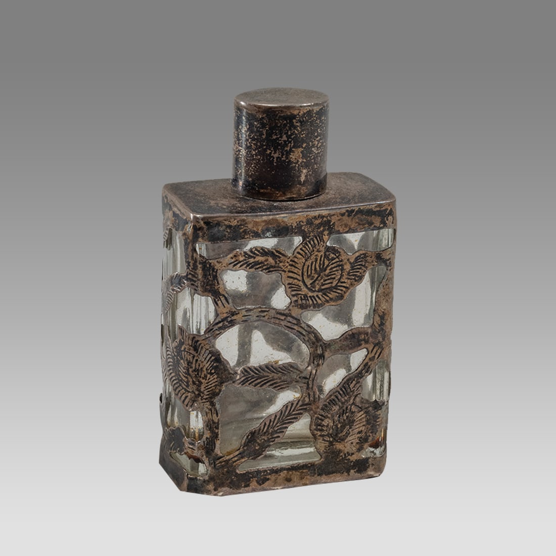 Antique Small Silver overlay Glass Bottle.: Antique Small Silver overlay Glass Bottle. Size 2 5/8 inches high. A small glass bottle with silver overlay with lid.