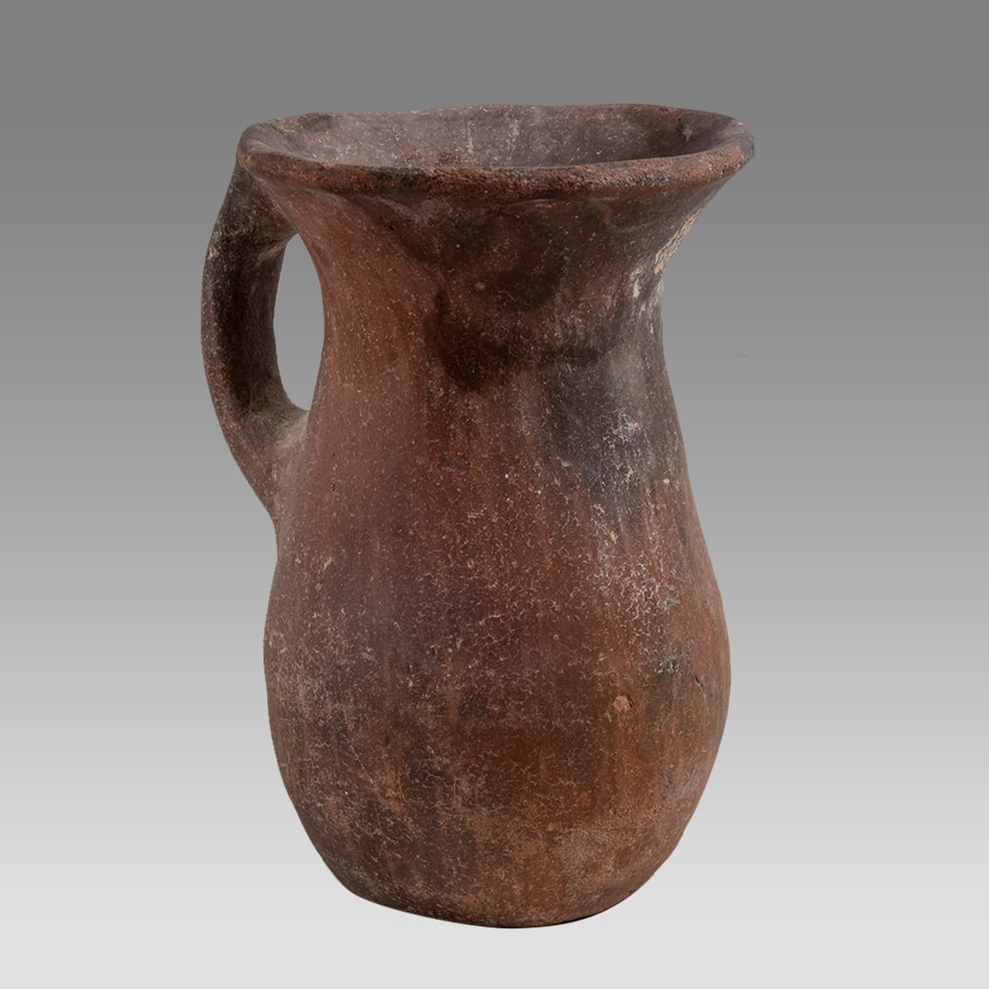 Ancient Pre Columbian pottery Cup.Ca. 800-1200 A.D.: Ancient Pre Columbian pottery Cup.Ca. 800-1200 A.D. Size 4 5/8 inches high. Fine plain red pottery cup with strap handle. Provenance: Property of Nanci McGonigal, Collection of Walter J. Bray, Mantolo