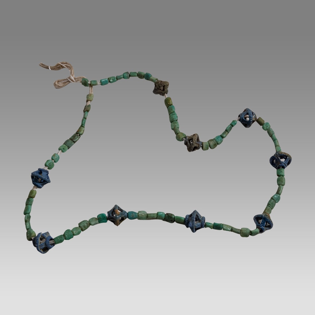 Ancient Roman Faience and Glass Bead Necklace c.2nd century AD.: Ancient Roman Faience and Glass Bead Necklace c.2nd century AD. Size 22 inches length. Unusual Roma green glass beads with blue faience beads with open work. Provenance: Private collection, bought in