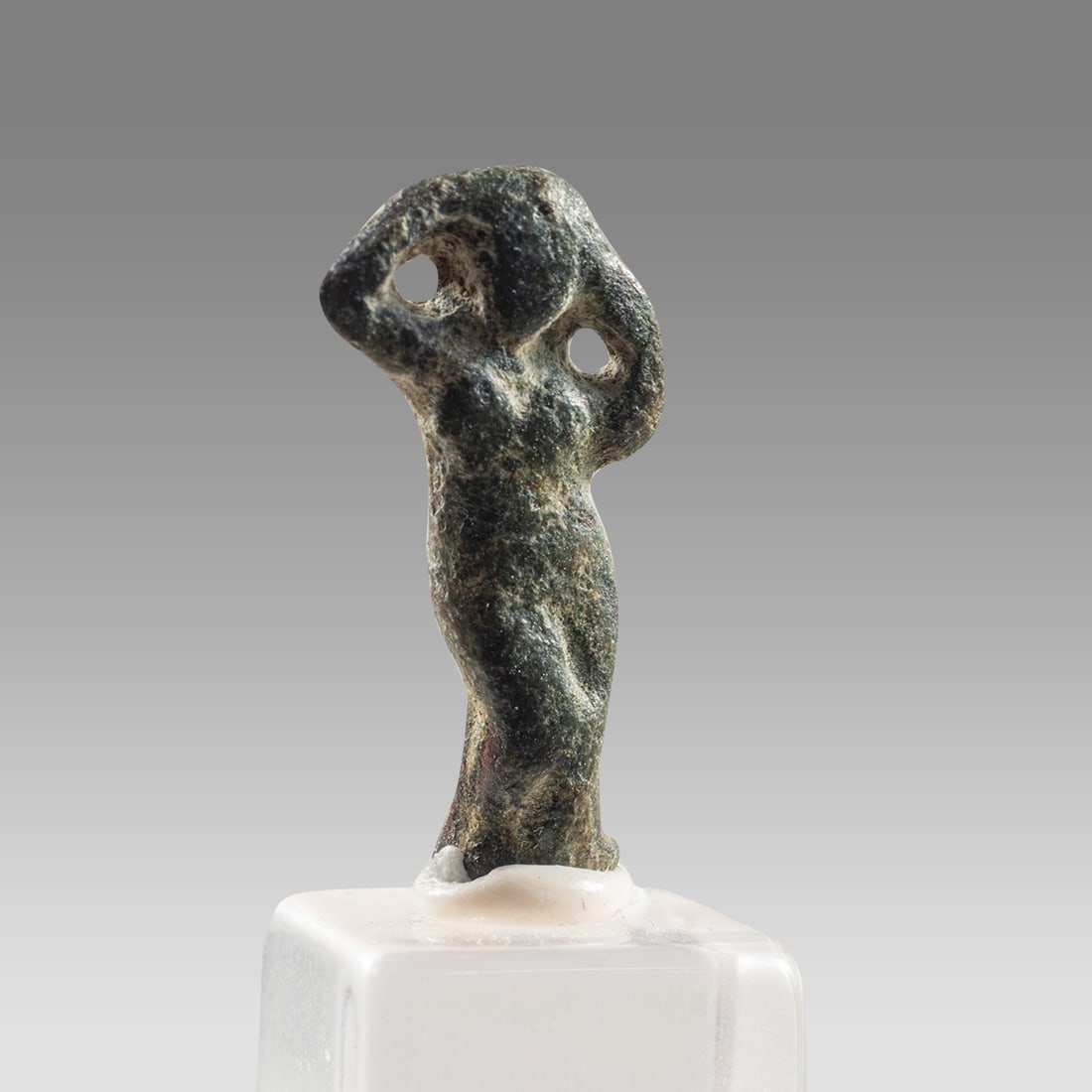 Aphrodite Anadyomene (Venus) Amulet, Bronze, Graeco-Roman c 3rd C BCE-2nd C CE,: Aphrodite Anadyomene (Venus) Amulet, Bronze, Graeco-Roman c 3rd C BCE-2nd C CE, Size 19x4x4mm, intact with loop at the back. Lucite stand. A lovely bronze amulet of the goddess Aphrodite (Roman Venus)