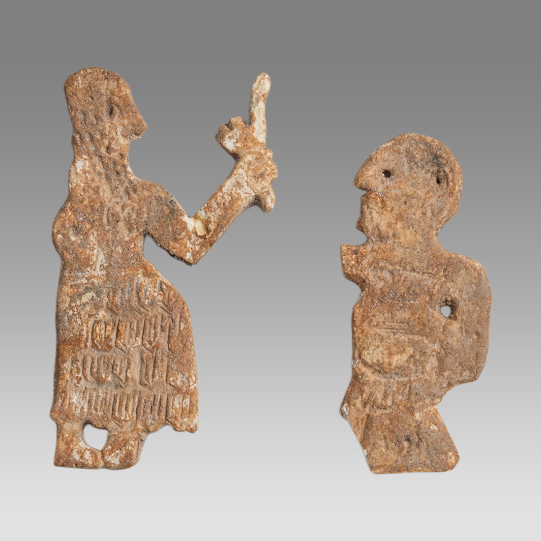 Lot of 2 Ancient Mesopotamian Bone Figure Applique c.3000 BC.: Lot of 2 Ancient Mesopotamian Bone Figure Applique c.3000 BC. Size 1 7/8 - 2 1/8 inch length. Fine carved bone applique depicting male figures with suspension holes. Provenance: Ex Florida collection