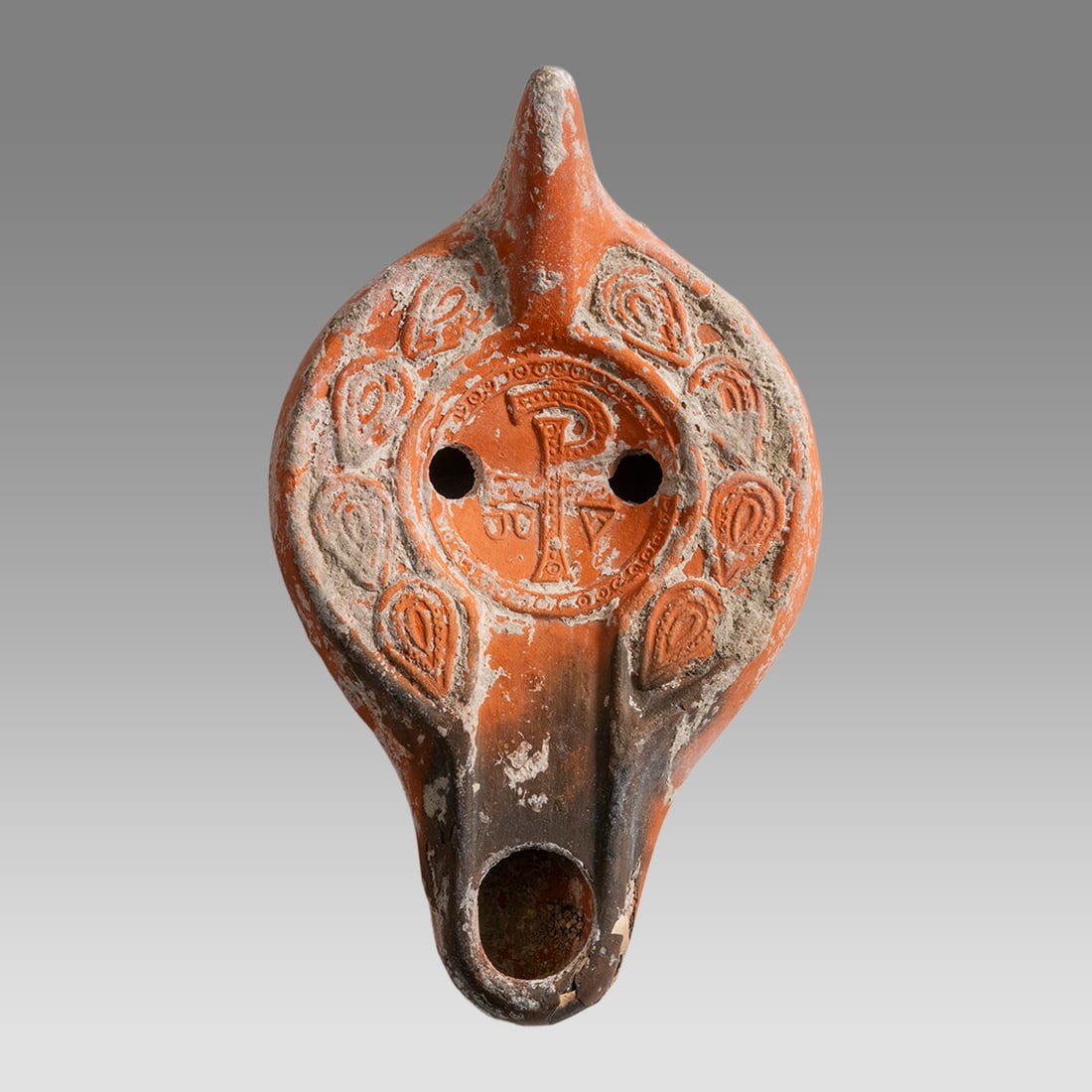 Ancient Byzantine North African Terracotta Oil Lamp With Chi-Rho symbol c.5th cent CE.: Ancient Byzantine North African Terracotta Oil Lamp With Chi-Rho symbol c.5th cent CE. Size 5 1/2 inches length, 3 1/4 inches width. with central filling, and a single spout along edge. decorated with