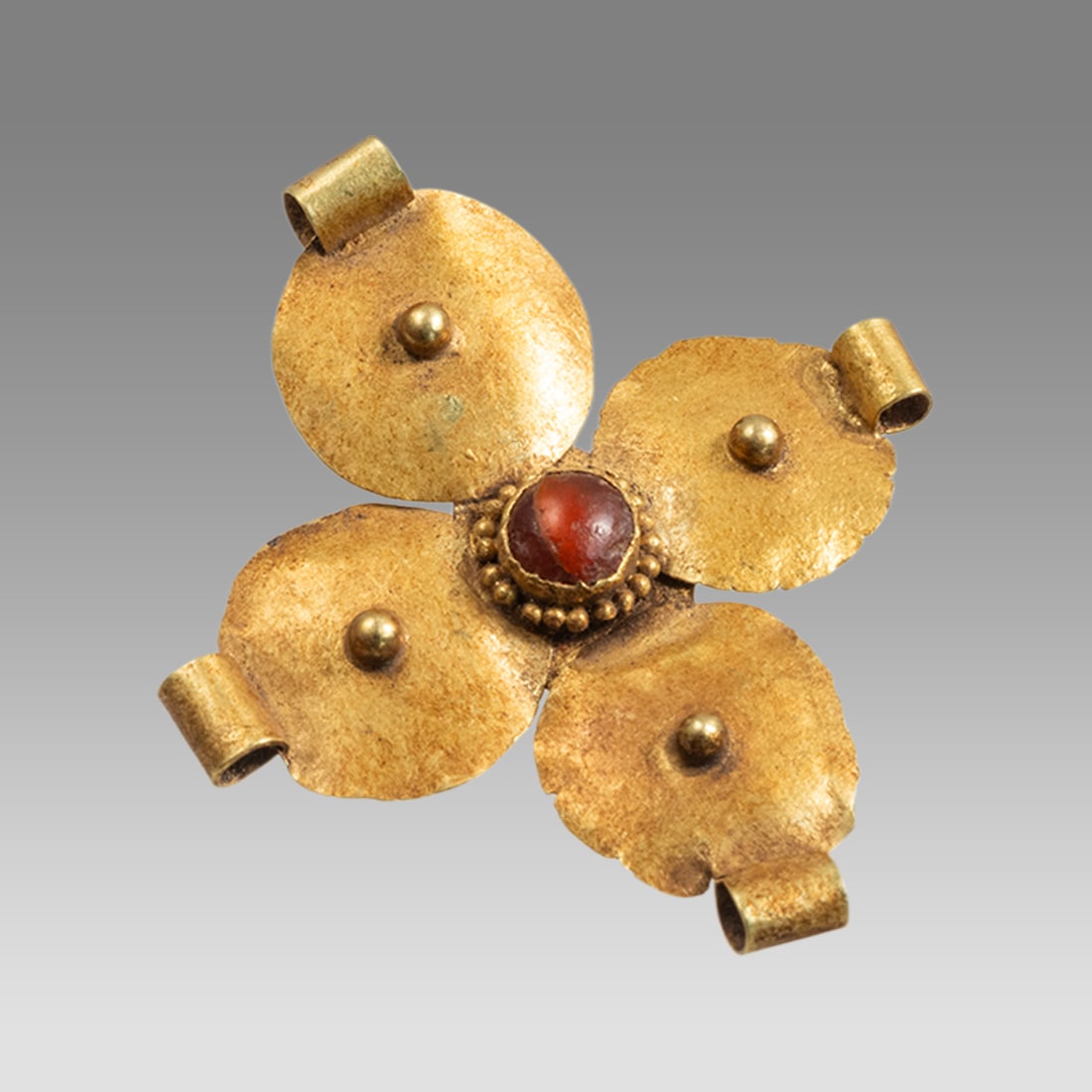 Ancient Byzantine Gold Cross c.6th-8th century AD.: Ancient Byzantine Gold Cross c.6th-8th century AD. Size 30 mm. Weight 1.60 grams. Ancient thin sheet of high karat gold cross with red agate in the center, four suspension loop. Provenance: Provenance