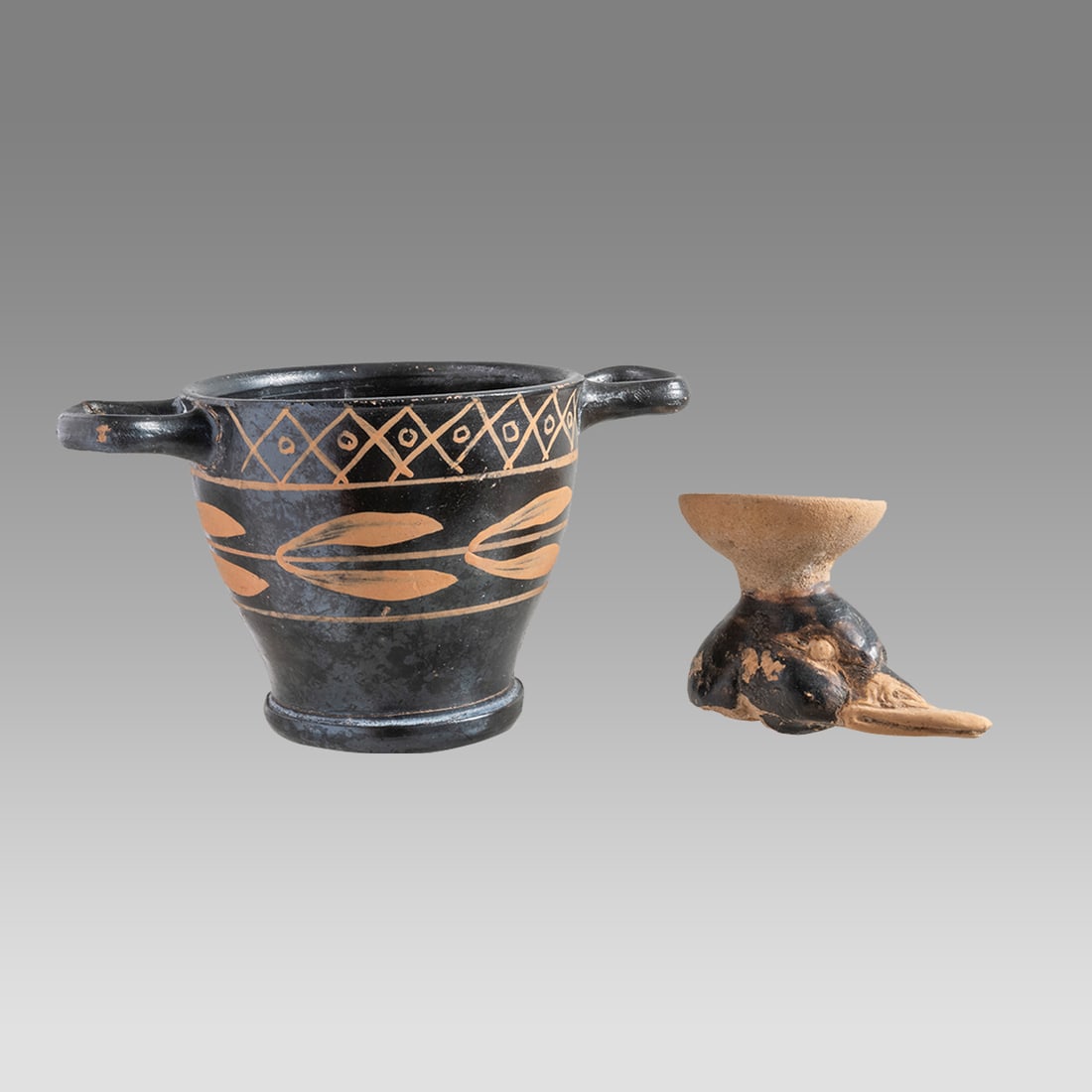 Lot of 2 Ancient Apulian Magna Graecia Kylix, Duck Head c.350 BC.: Lot of 2 Ancient Apulian Magna Graecia Kylix, Duck Head c.350 BC. Size 2 1/2 - 5 inches length. 1 3/4 - 2 3/4 inches high. Apulian Pottery kylix with twin handles, decorated with leafs. together with