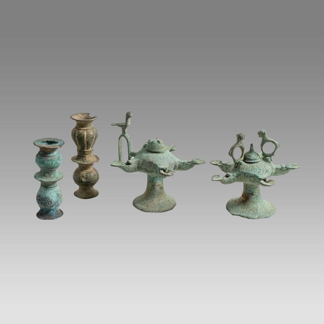 Lot of 4 Islamic Seljuk Bronze Oil Lamps, Candlesticks Post c.10th century AD.: Lot of 4 Islamic Seljuk Bronze Oil Lamps, Candlesticks Post c.10th century AD. Size 4 1/4 - 5 1/4 inches high. A collection of 2 Islamic bronze oil lamps, together with candlestick fragments. Provenan