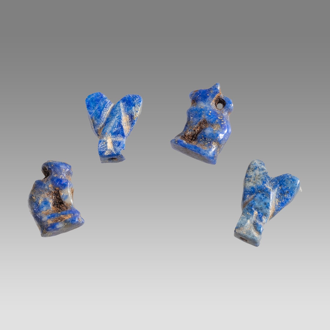 Lot of 4 Ancient Egyptian Lapis Lazuli Amulets c.300-50 BC.: Lot of 4 Ancient Egyptian Lapis Lazuli Amulets c.300-50 BC. Size 8-10 mm. Fine small carved lapis lazuli amulets all with suspension hole. Provenance: Ex Secret Eyes Gallery New York 1970's-1980's.