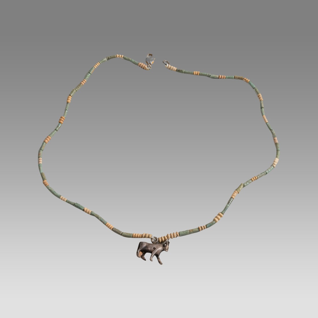 Ancient Egyptian Faience Bead Necklace With Silver Apis Bull Amulet c.625 BC.: Ancient Egyptian Faience Bead Necklace With Silver Apis Bull Amulet c.625 BC. Size 18 1/4 inches length, Fine faience beads neclace with fine cast silver Apis bull amulet. The amulet has a new suspens