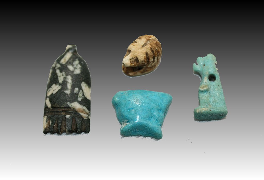 Lot of Four Egyptian Amulets XXVI Dynasty: Lot of Four Egyptian Amulets XXVI Dynasty. comprised of a diorite counterpoise with fringed edge (See "Amulets of Ancient Egypt" by Carol Andrews. p.96h) an unglazed faience hedgehog, A glazed faience
