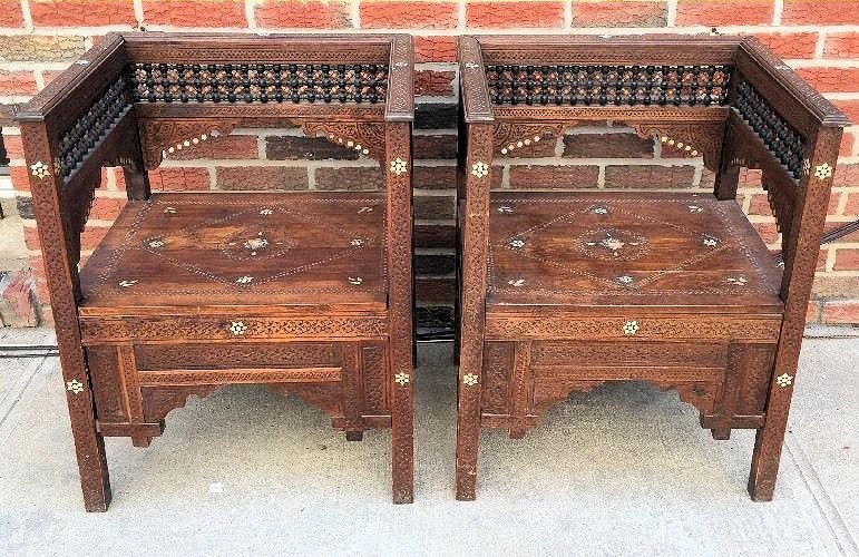 A Pair of Syrian Carved wood arm chairs inlaid with: A Pair of Syrian Carved wood armchairs inlaid with Mother-of-Pearl, early 20th Century. Size H.- 28 3/4 in., W.- 22 1/4 inches wide And 19 1/2 inches deep. From a New Orleans estate.