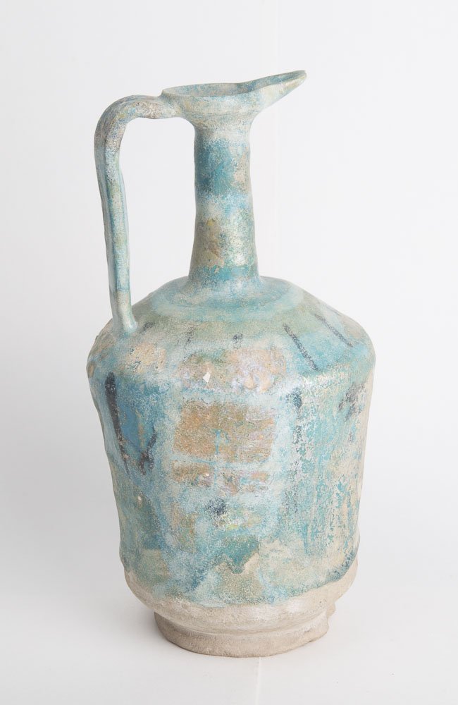 A KASHAN TURQUOISE-GLAZED POTTERY JUG c.13TH CENTURY AD: A KASHAN TURQUOISE-GLAZED POTTERY JUG c.13TH CENTURY AD. Round body with long neck, side handle, black lines under glaze, Great Iridescence. Size 10 1/4 inches high, 5 inches diameter. old repair with