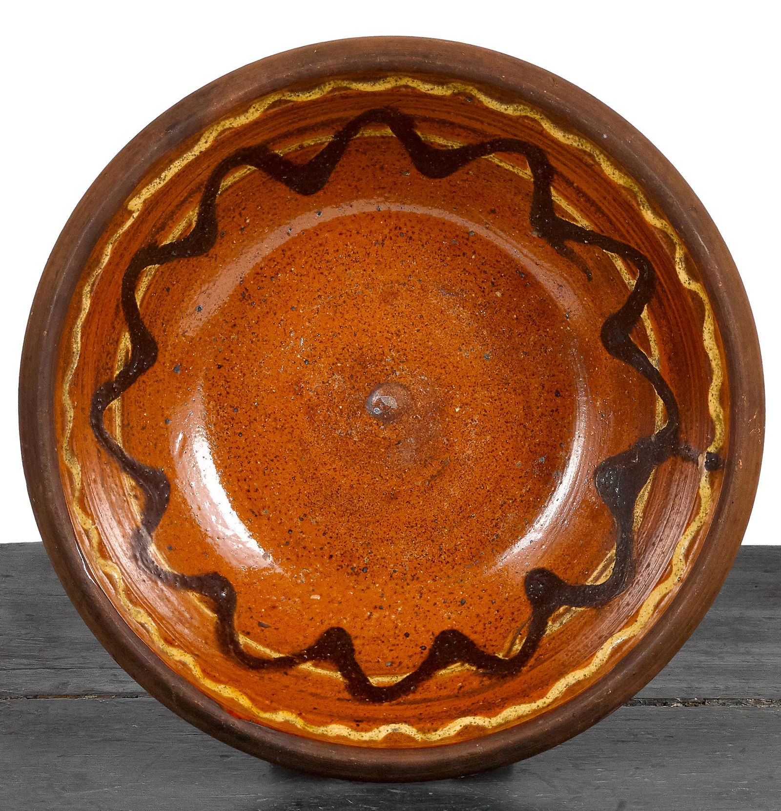 Pennsylvania redware bowl: Pennsylvania redware bowl, 19th c., with a yellow and brown slip decorated center, 3'' h., 9'' dia.
