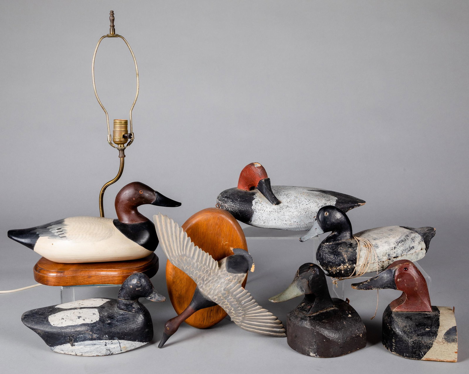 Five carved and painted duck decoys: Five carved and painted duck decoys, together with a decoy lamp, probably Madison Mitchell, a flying duck plaque, and two buoys.