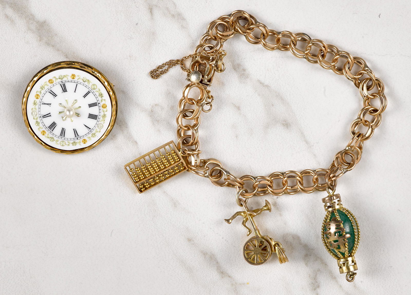Chinese charm bracelet: Chinese charm bracelet, with a gold filled chain and 14K and gold filled charms, 7'' l., together with a watch face brooch with 14K gold detailing, 1 1/8'' dia.