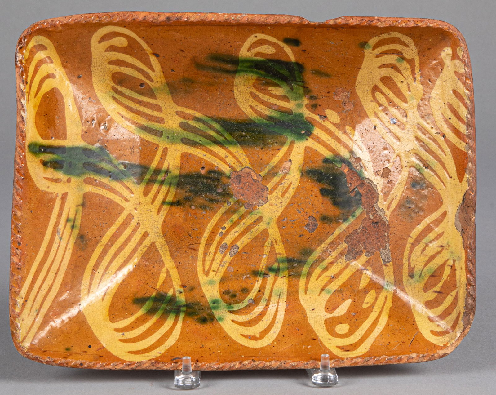 New England redware loaf dish: New England redware loaf dish, 19th c., with yellow and green slip decoration, 10 3/4'' h., 13 3/4'' w.
