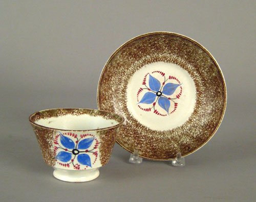 Brown spatter cup and saucer, 19th c., with blu: Brown spatter cup and saucer, 19th c., with blue four petal flower.