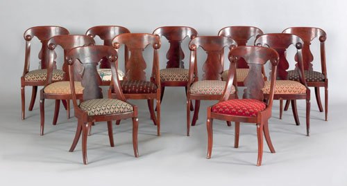 Set of eleven classical mahogany saber leg dinin: Set of eleven classical mahogany saber leg dining chairs, ca. 1835, each with an arched crest with applied rosettes at the ends, above a solid splat and bowfront seat.