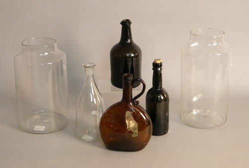 Two colorless glass apothecary jars, together wit: Two colorless glass apothecary jars, together with a decanter and three bottles.