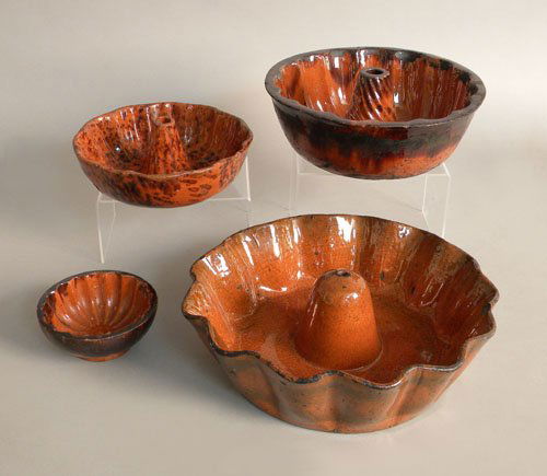 Four Pennsylvania redware food molds, 19th c., th: Four Pennsylvania redware food molds, 19th c., three with manganese splash decoration, 4 1/4'' to 10 1/4'' dia.