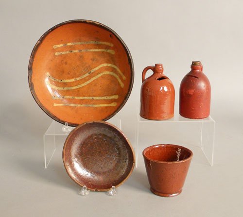 Two earthenware banks, 19th c., together with a s: Two earthenware banks, 19th c., together with a small redware cup, a slipware pie plate and small dish.