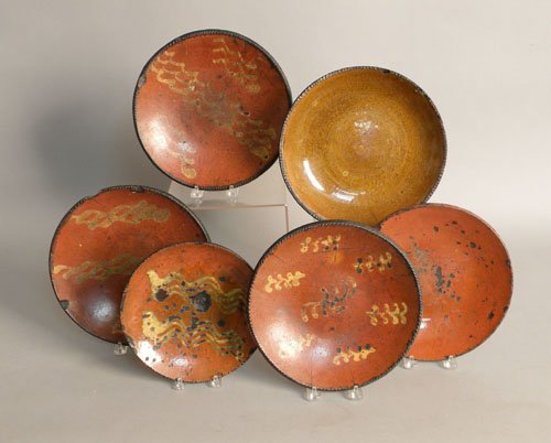 Six Pennsylvania redware plates, 18th c., some wi: Six Pennsylvania redware plates, 18th c., some with yellow slip decoration, 8'' - 10'' dia. (losses; chips; cracks; hairlines).