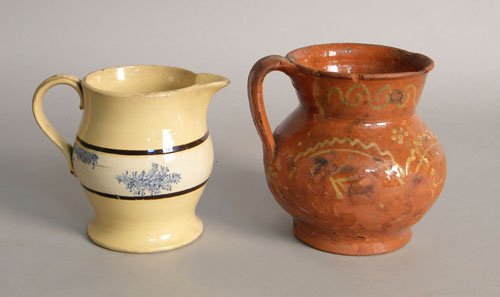 Mochaware yelloware cream pitcher, 19th c., with: Mochaware yelloware cream pitcher, 19th c., with seaweed decoration together with slip decorated redware pitcher, 6'' h.