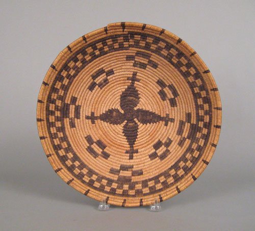 Apache coiled basketry bowl, the border decorat: Apache coiled basketry bowl, the border decorated with darts and checkered band centering on a cross, 3 1/2'' h., 15'' dia.