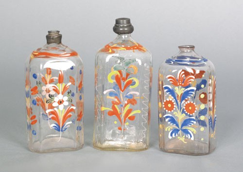 Three Stiegel type glass enamel decorated bottle: Three Stiegel type glass enamel decorated bottles, ca. 1800, with pewter stoppers, 6 1/4'' h., 5 1/2'' h., and 5'' h.