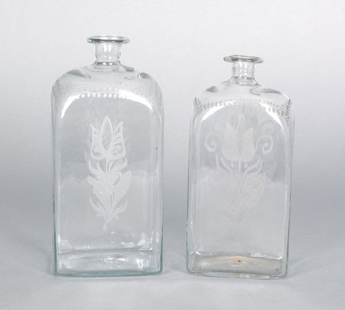 Two Stiegel type etched colorless glass bottles,: Two Stiegel type etched colorless glass bottles, ca. 1800, with double sided tulip decoration, 8 1/4'' h. and 9'' h.