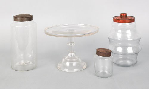 Three clear glass canisters, 19th c., one with : Three clear glass canisters, 19th c., one with a red tin lid, tallest - 9 3/4'' h., together with a cake stand.