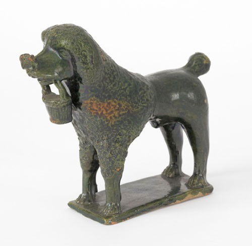 Redware figure of a spaniel, 19th c., clutching: Redware figure of a spaniel, 19th c., clutching a basket in its mouth, 7'' h.