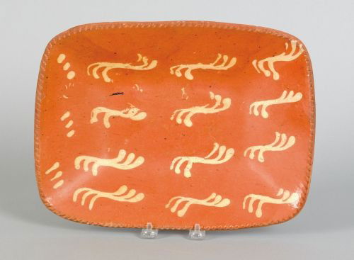 Pennsylvania slip decorated redware loaf dish, e: Pennsylvania slip decorated redware loaf dish, early 19th c., having triple quill wavy lines, 13'' h., 9 3/4'' w.