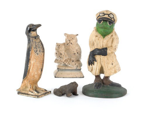 Four cast iron animal doorstops to include frog i: Four cast iron animal doorstops to include frog in jacket, penguin, owls, and frog, tallest 12 1/2'' h.