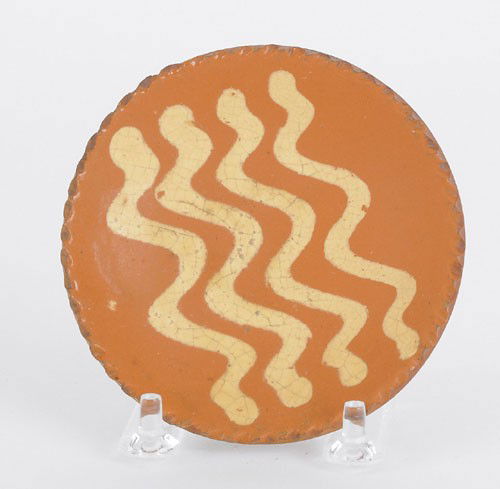 Miniature redware plate, 19th c., with four yel: Miniature redware plate, 19th c., with four yellow slip wavy lines, 4'' dia. Provenance: Christies, Collection of Paul Flack, September 6, 1997.