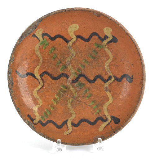Pennsylvania redware pie plate, 19th c., with y: Pennsylvania redware pie plate, 19th c., with yellow, brown, and green slip decoration, 7 3/4'' h.