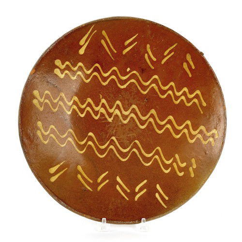 Pennsylvania redware charger, 19th c., with yel: Pennsylvania redware charger, 19th c., with yellow slip wavy line and dash decoration, 12'' dia.
