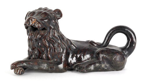 Earthenware figure of a recumbent lion, 19th c.: Earthenware figure of a recumbent lion, 19th c., 10'' h., together with a Rockingham glazed seated spaniel, 10 3/4'' h.