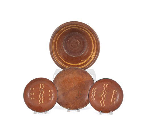 Three pieces of slip decorated redware, 19th c.,: Three pieces of slip decorated redware, 19th c., to include a bowl, 4 1/2'' h. and two plates, 11 1/2'' dia., together with another redware plate.