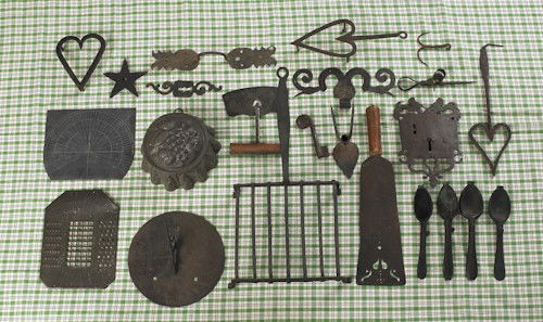 Miscellaneous metalware, 19th c., to include hear: Miscellaneous metalware, 19th c., to include heart trivets, escutcheons, a chopper, a pricket stick, pewter spoon molds, a brass sundial, a slate sundial, etc.