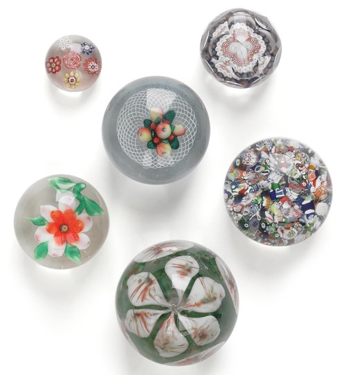 Six early glass paperweights, to include a New: Six early glass paperweights, to include a New England example with a fruit bouquet on a latticinio ground, mid 19th c., three millefiori examples, an egg shaped example with a lily, and one with a fl