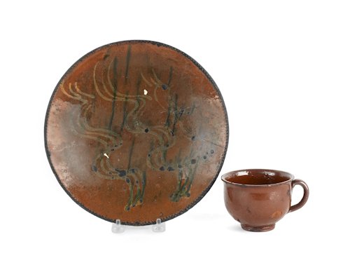Two pieces of Pennsylvania redware, 19th c., to i: Two pieces of Pennsylvania redware, 19th c., to include a two colored slip decorated plate, 10 1/4'' dia., and a handled mug.