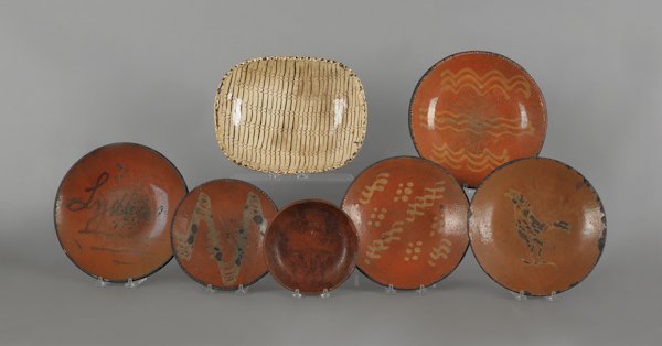 Six American redware plates, 19th c., together wi: Six American redware plates, 19th c., together with an English loaf dish.
