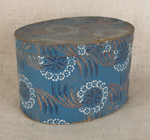 Wallpaper hat box, 19th c., with floral decorat: Wallpaper hat box, 19th c., with floral decoration on a blue ground, 10'' h., 16'' w.