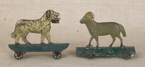 Two painted tin pull toys, early 19th c., to in: Two painted tin pull toys, early 19th c., to include a ram and a dog with a basket, 4 3/4'' h., 6'' l. and 4 3/4'' h., 6 1/4'' l.