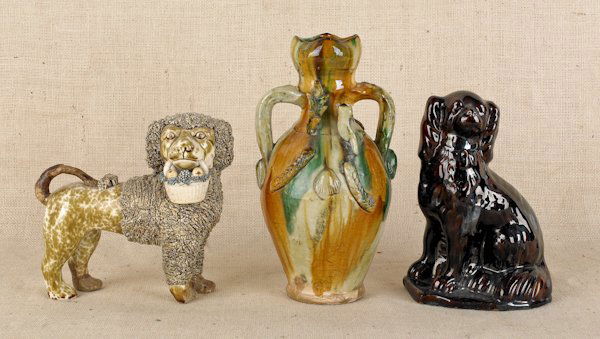 Bennington flint enameled spaniel, 19th c., wit: Bennington flint enameled spaniel, 19th c., with coleslaw mane, 8 1/2'' h., together with a Rockingham glazed spaniel, 9 3/4'' h., and a redware vase, 12'' h.