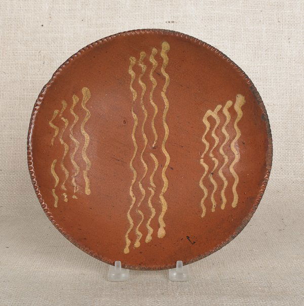 Pennsylvania redware pie plate, 19th c., with y: Pennsylvania redware pie plate, 19th c., with yellow slip squiggle line decoration, 9'' dia.