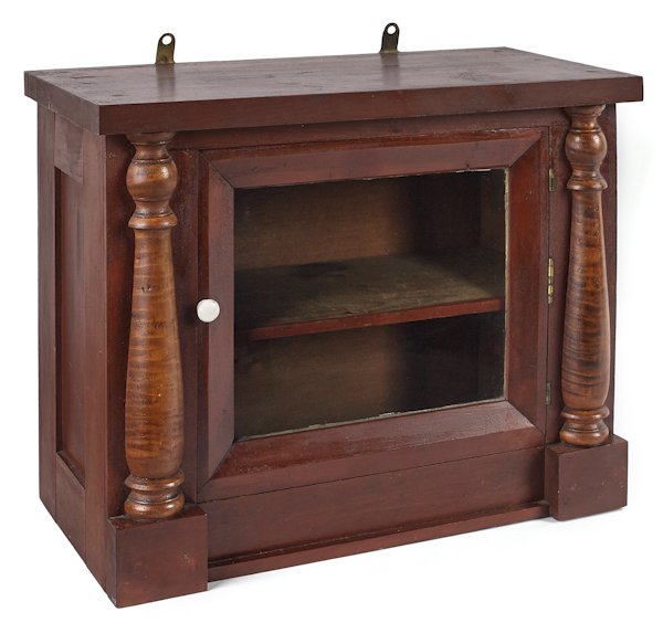 Pennsylvania cherry hanging cabinet, ca. 1830,: Pennsylvania cherry hanging cabinet, ca. 1830, with tiger maple half columns, retaining an old red wash surface, 15'' h., 18'' w.