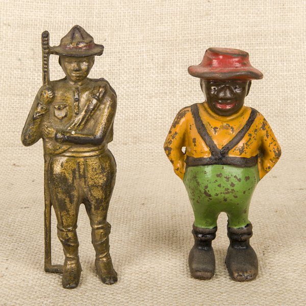 Two cast iron still banks, one of a boy scout, 6'': Two cast iron still banks, one of a boy scout, 6'' h., the other of a black Americana sharecropper, 5 1/2'' h.